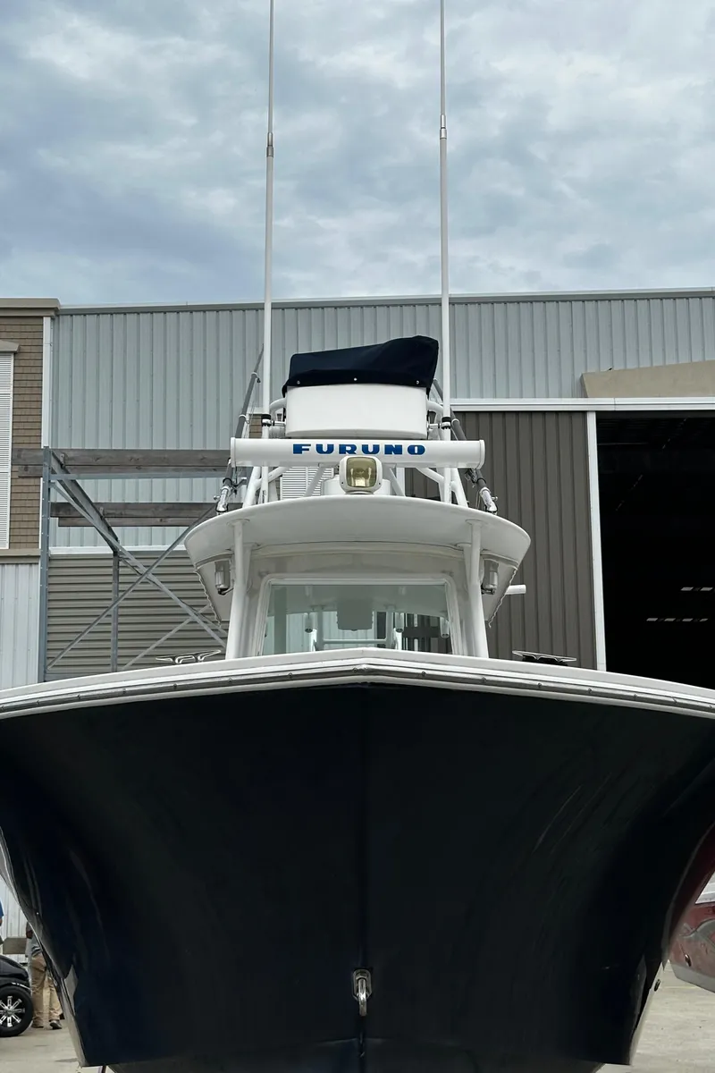 Slide: The Image of 2005 Regulator 32 FS boat docked near a warehouse. - 5