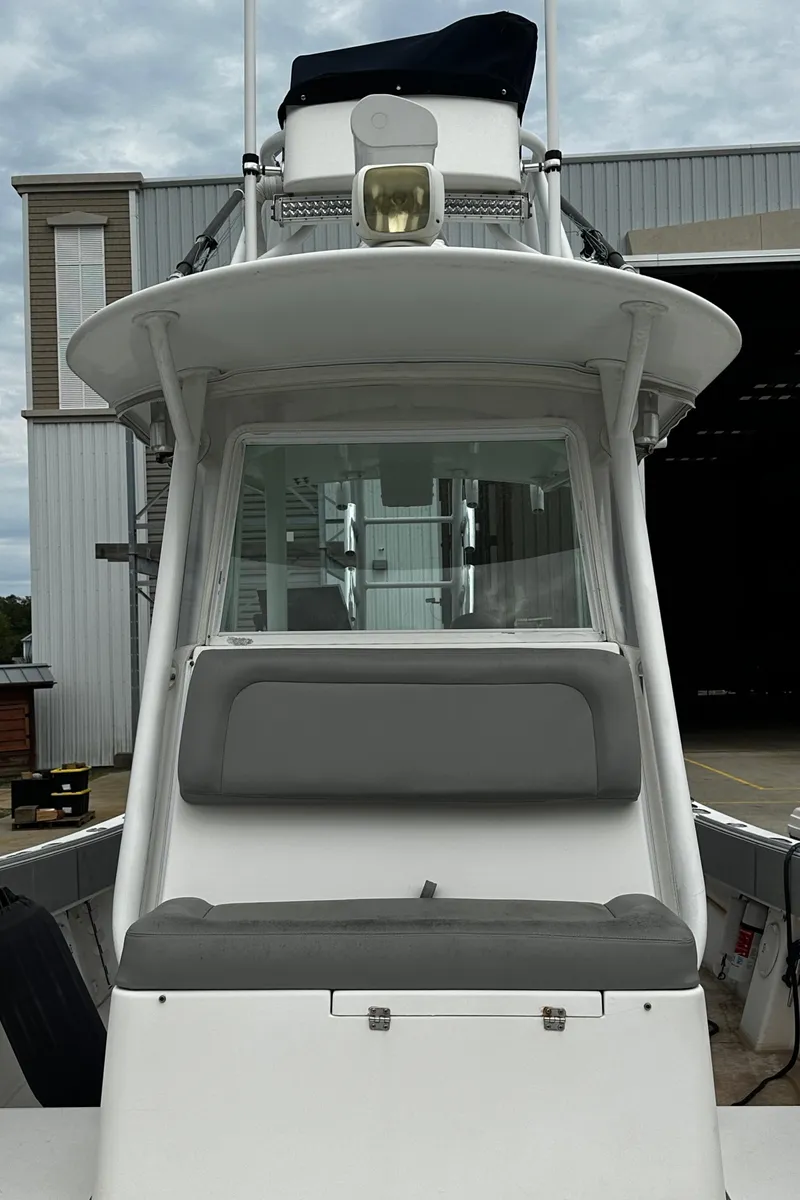 Slide: The Image of 2005 Regulator 32 FS boat with gray seating, docked near a building. - 8