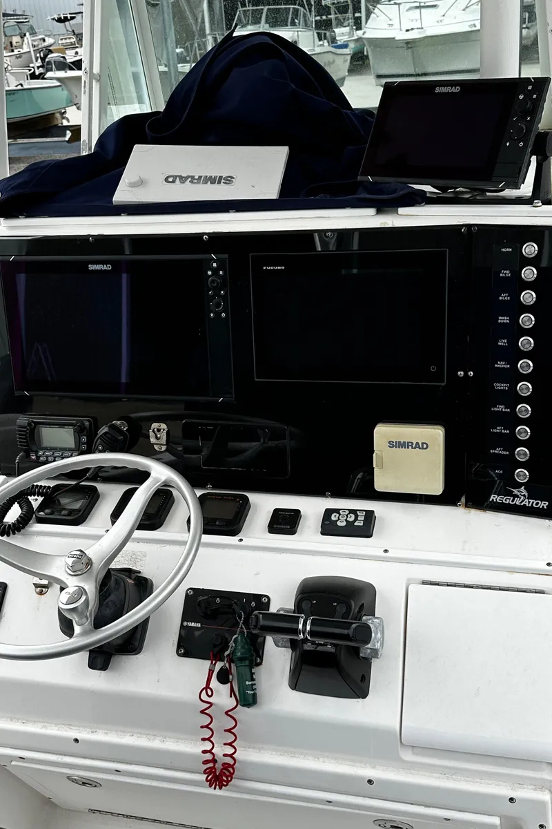 Slide: The Image of 2005 Regulator 32 FS boat dashboard with navigation equipment and steering wheel. - 9