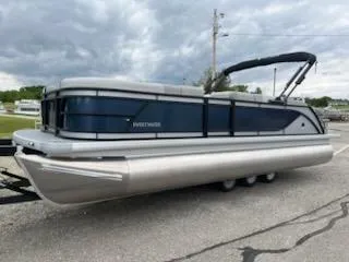 Slide: The Image of 2025 Godfrey SWEETWATER 2286SFL pontoon boat on a trailer, under cloudy skies. - 9