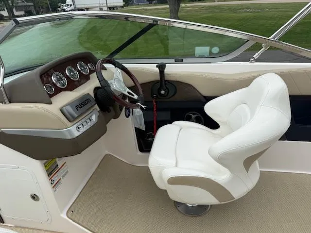 Slide: The Image of Interior of 2012 Regal 24 FasDeck boat with steering wheel and white captain's chair. - 12