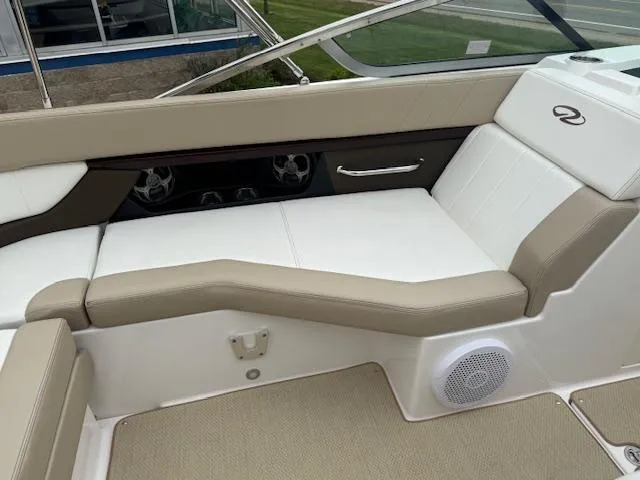 Slide: The Image of 2012 Regal 24 FasDeck boat interior with beige and white seating, speaker, and cup holders. - 18