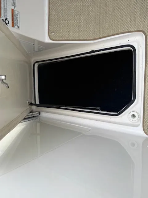 Slide: The Image of 2012 Regal 24 FasDeck storage compartment with open hatch and hydraulic support. - 20