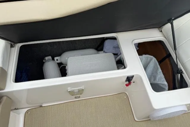 Slide: The Image of Storage compartment in a 2012 Regal 24 FasDeck boat, containing fenders and a cooler. - 36