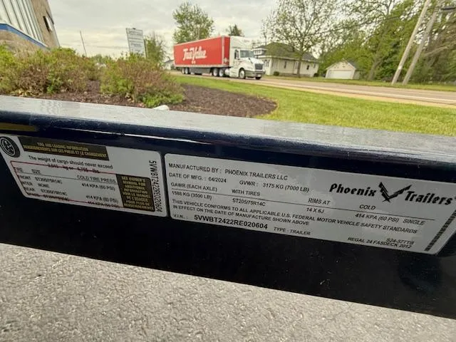 Slide: The Image of Trailer label with specifications, Phoenix Trailers, near road with truck in background. - 38