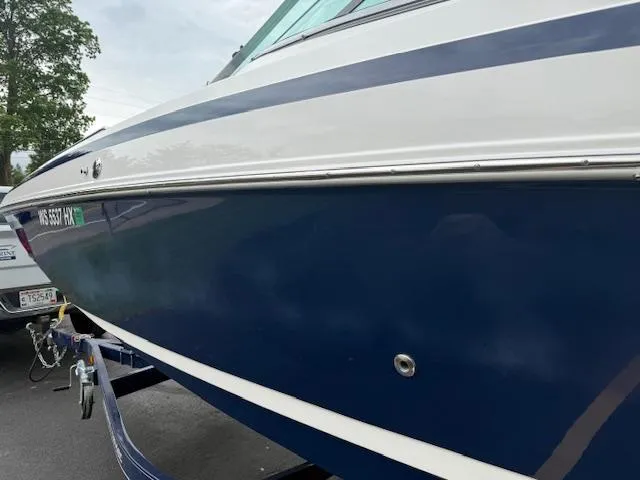 Slide: The Image of 2012 Regal 24 FasDeck boat with blue and white exterior on a trailer. - 5