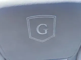 Slide: The Image of Godfrey EX2286SBCX 2025 seat with embroidered 'G' logo on gray upholstery. - 10