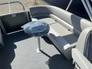 Slide: The Image of 2025 Godfrey EX2286SBCX boat interior with gray seating and table. - 12