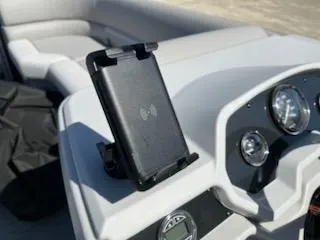Slide: The Image of 2025 Godfrey EX2286SBCX boat dashboard with phone holder and gauges. - 9