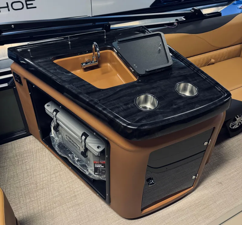 Slide: The Image of 2025 Tahoe Pontoon LTZ Elite Windshield interior with sink, cup holders, and storage. - 11