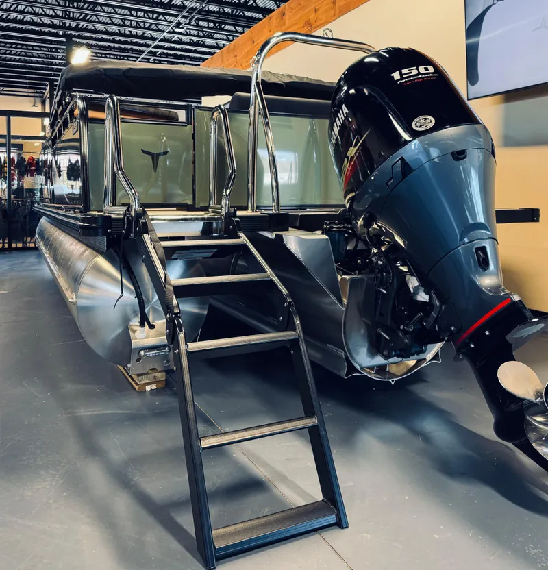 Slide: The Image of 2025 Tahoe Pontoon LTZ Elite Windshield with powerful 150 HP engine, showcased indoors. - 2