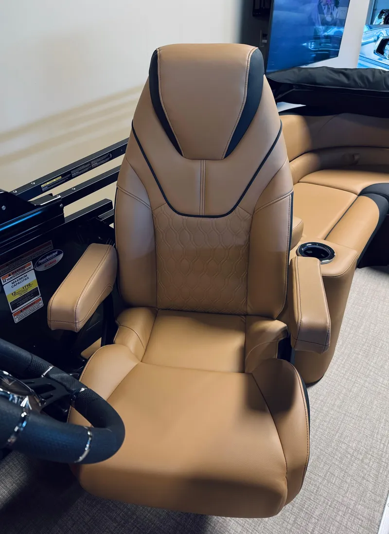 Slide: The Image of 2025 Tahoe Pontoon LTZ Elite Windshield captain's chair with tan upholstery and armrests. - 6
