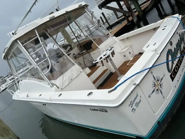 Slide: The Image of 1992 Luhrs Tournament 290 Open boat docked at marina, featuring spacious deck and cabin. - 2