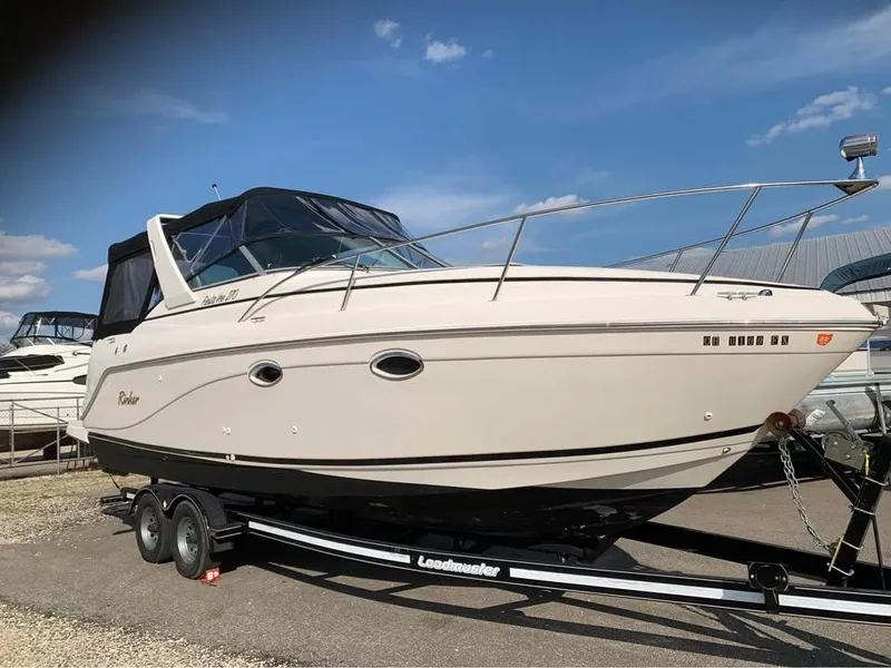 Slide: The Image of 2003 Rinker 270 boat on trailer under clear blue sky. - 1