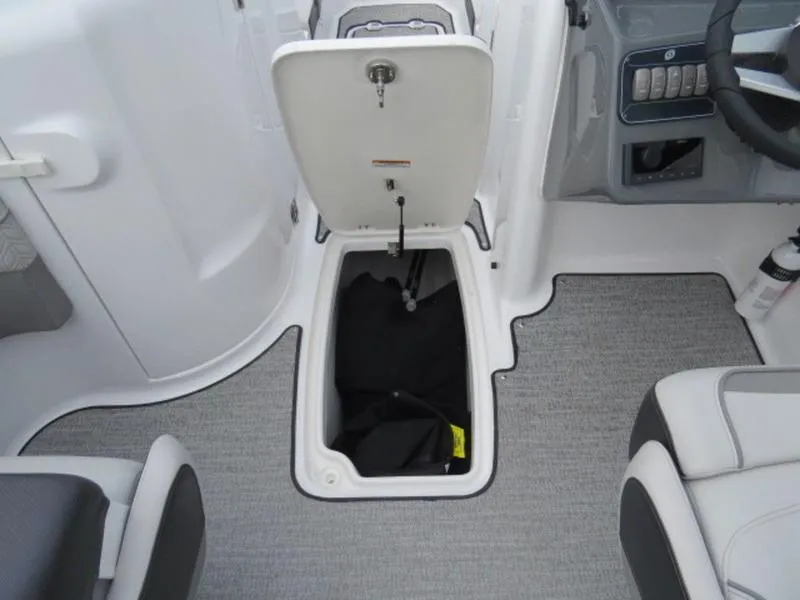 Slide: The Image of 2023 Hurricane SunDeck 2400 OB interior storage compartment with open hatch and seating. - 23