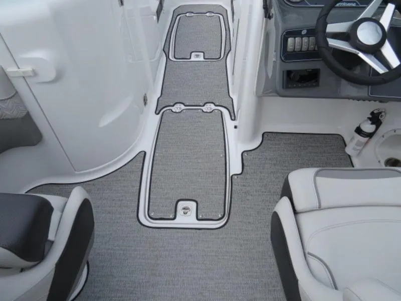 Slide: The Image of 2023 Hurricane SunDeck 2400 OB boat interior with gray carpet and steering wheel. - 24