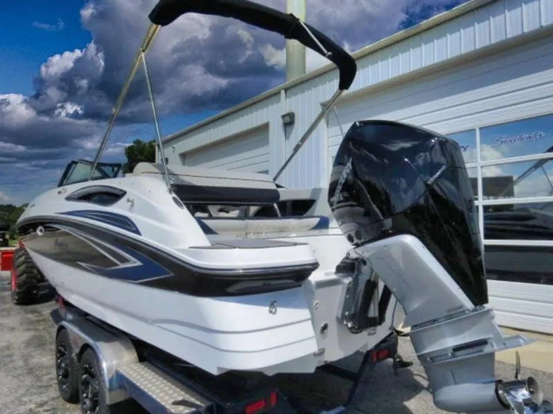 Slide: The Image of 2023 Hurricane SunDeck 2400 OB boat on trailer, featuring sleek design and powerful outboard motor. - 5