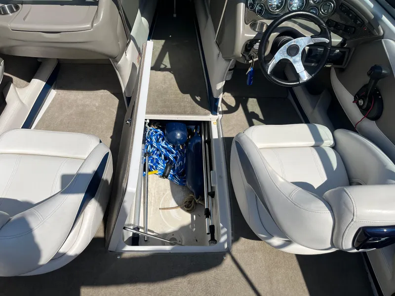 Slide: The Image of 2008 Crownline 23SS boat interior with open storage compartment and steering wheel. - 14