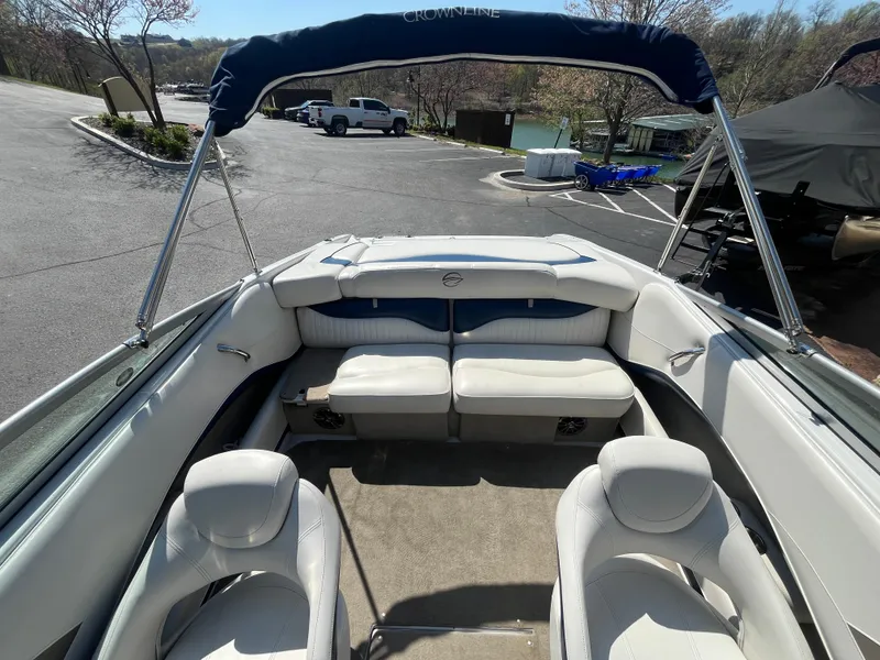 Slide: The Image of 2008 Crownline 23SS boat interior with seating and canopy in a parking lot. - 18