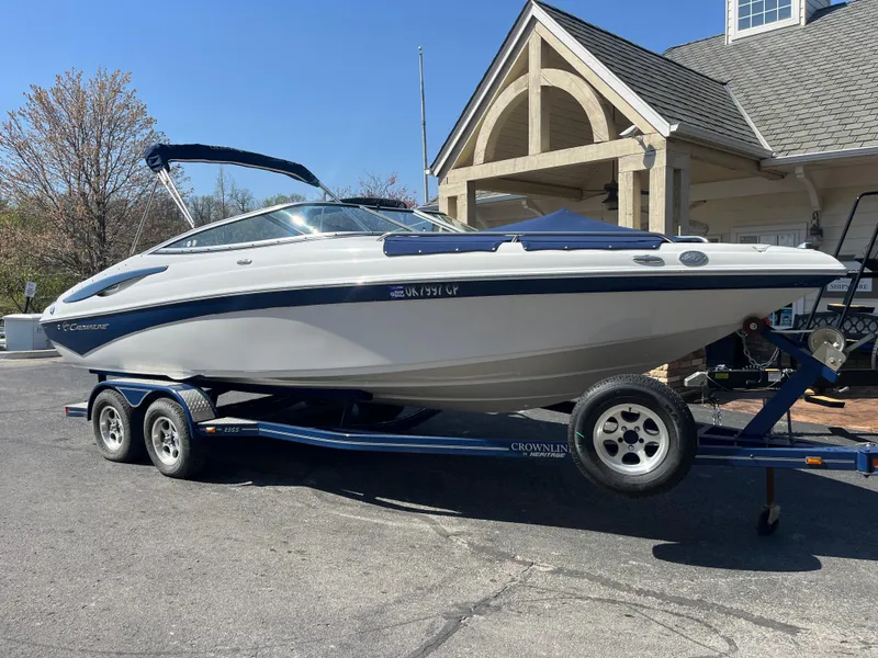 Slide: The Image of 2008 Crownline 23SS boat on trailer, parked near a house. - 2