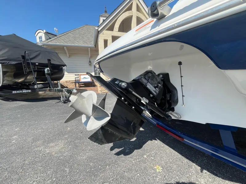 Slide: The Image of 2008 Crownline 23SS boat with visible propeller and outdrive, parked on a driveway. - 29
