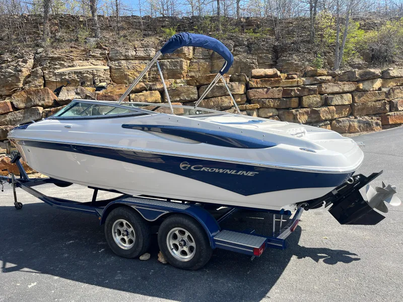 Slide: The Image of 2008 Crownline 23SS boat on trailer, parked outdoors near stone wall. - 32