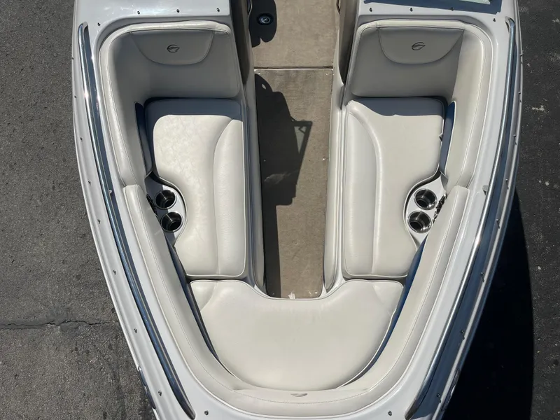 Slide: The Image of 2008 Crownline 23SS boat interior with white cushioned seating and cup holders. - 6