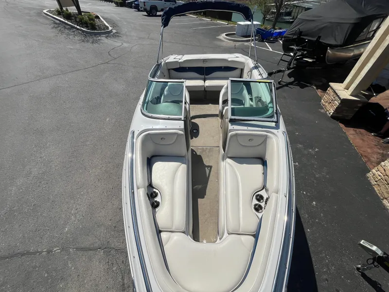 Slide: The Image of 2008 Crownline 23SS boat with white interior, parked on asphalt. - 7