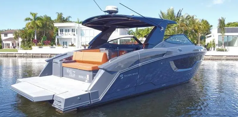 Slide: The Image of 2023 Cruisers Yachts 38 GLS luxury boat docked by waterfront homes. - 1