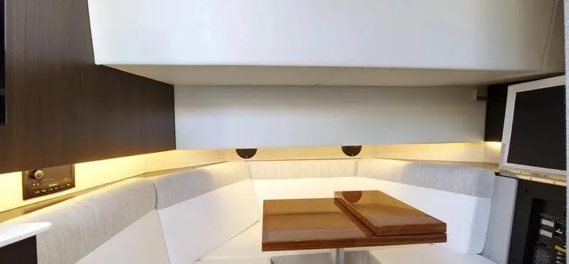 Slide: The Image of 2023 Cruisers Yachts 38 GLS interior with modern seating and wooden table. - 11