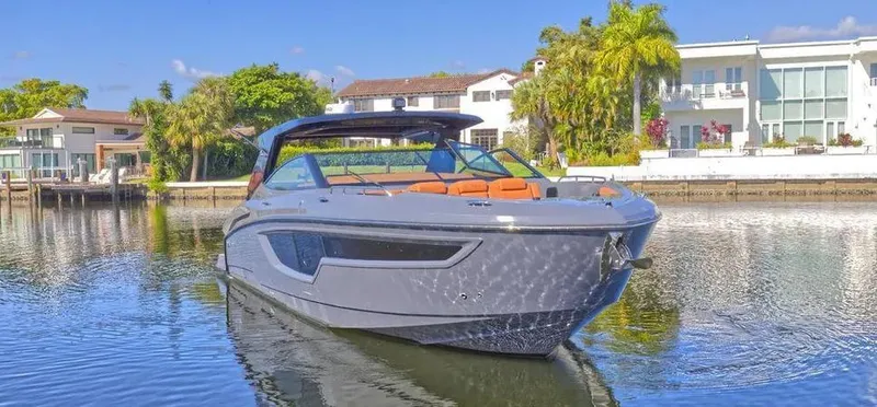 Slide: The Image of 2023 Cruisers Yachts 38 GLS on serene water near luxury waterfront homes. - 7