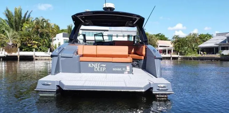 Slide: The Image of 2023 Cruisers Yachts 38 GLS on water, rear view with seating, Miami backdrop. - 8