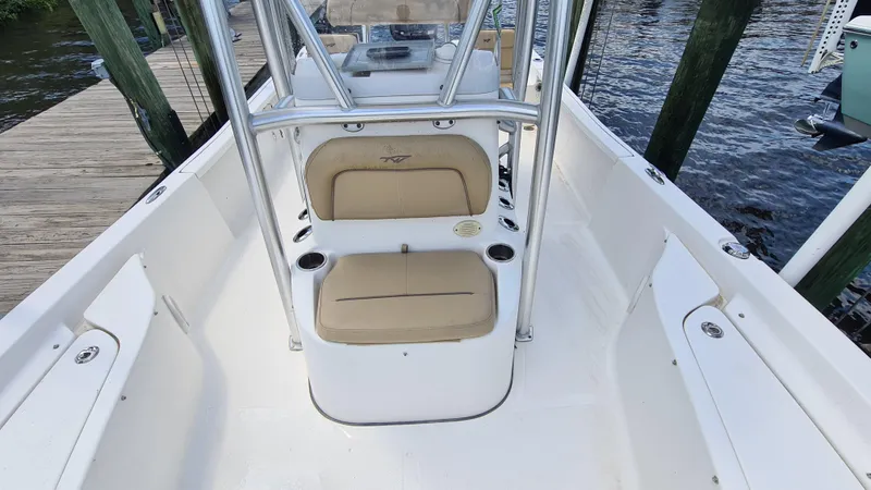 Slide: The Image of 2016 Tidewater 2200 Carolina Bay boat interior with seating and console, docked by the water. - 10