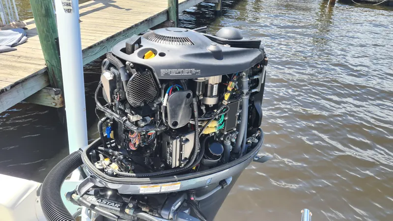 Slide: The Image of Open engine of a 2016 Tidewater 2200 Carolina Bay boat by the water. - 19