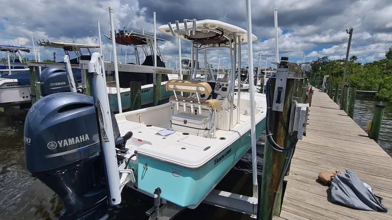 Slide: The Image of 2016 Tidewater 2200 Carolina Bay boat docked with Yamaha engine, under cloudy sky. - 2
