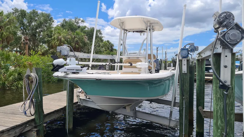 Slide: The Image of 2016 Tidewater 2200 Carolina Bay boat docked on lift, surrounded by water and trees. - 4