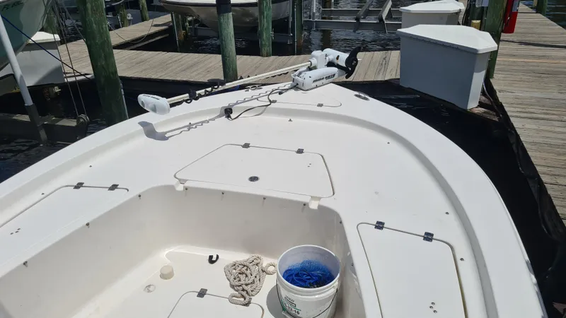 Slide: The Image of 2016 Tidewater 2200 Carolina Bay boat docked, featuring a trolling motor and fishing gear. - 7