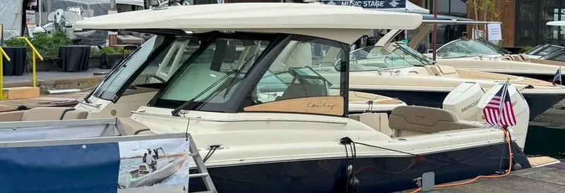 Slide: The Image of 2025 Chris-Craft Calypso 32 boat displayed at a marina, featuring sleek design and luxury amenities. - 1