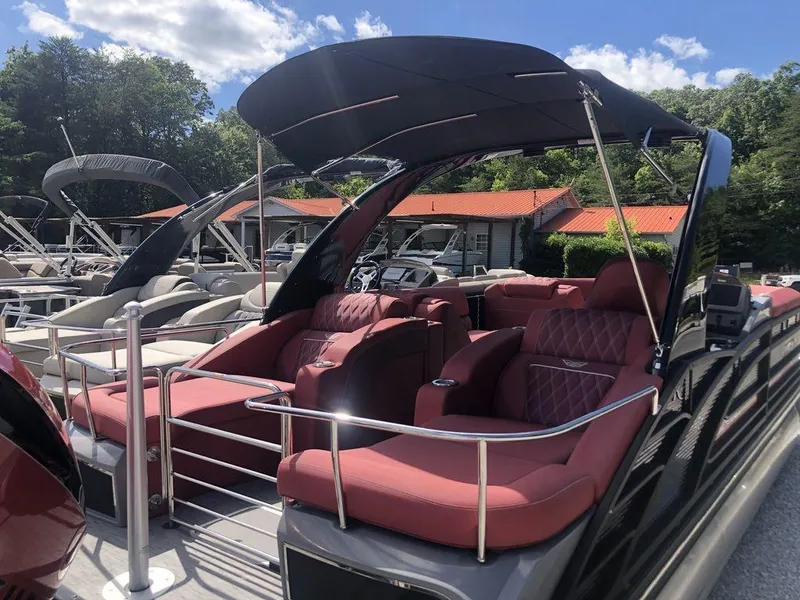 Slide: The Image of 2021 Bennington 23 RCWA pontoon boat with red seating and canopy, docked under blue sky. - 8