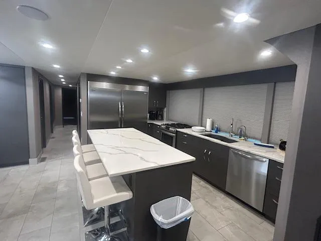 Slide: The Image of Modern kitchen interior on 2020 Adonia houseboat with sleek countertops and stainless steel appliances. - 17