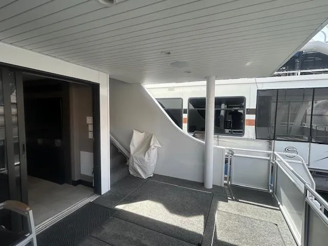 Slide: The Image of Adonia 2020 houseboat interior with stairs, modern design, and outdoor view. - 24