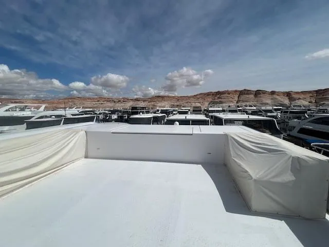 Slide: The Image of Rooftop view of 2020 Adonia houseboat with scenic desert backdrop and cloudy sky. - 35