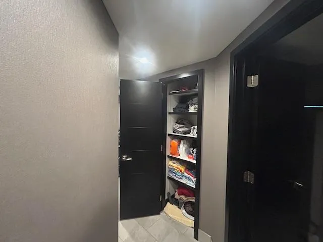Slide: The Image of Hallway with open closet on Adonia 2020 houseboat, featuring shelves with neatly organized clothes. - 6