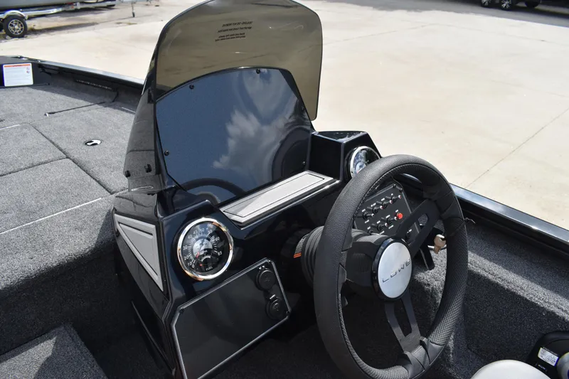 Slide: The Image of Open storage compartment in 2025 Lowe Stinger 175C boat, featuring gray carpeted interior. - 34