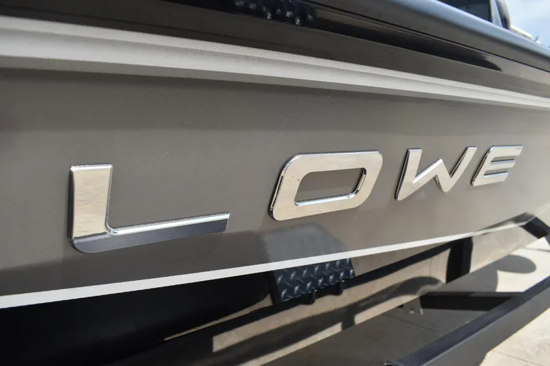 Slide: The Image of Rear view of 2025 Lowe Stinger 175C boat with safety warning label and trailer attachment. - 7