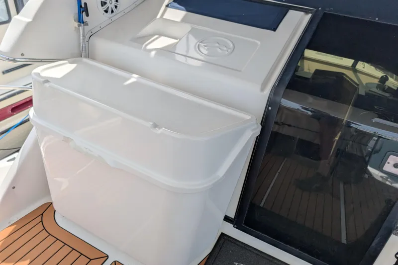 Slide: The Image of 2000 Bayliner 4088 boat interior with white storage compartment and wooden flooring. - 18