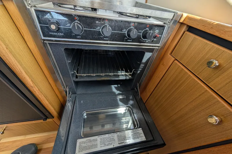 Slide: The Image of Open oven in 2000 Bayliner 4088 yacht kitchen, featuring wooden cabinetry and modern controls. - 25