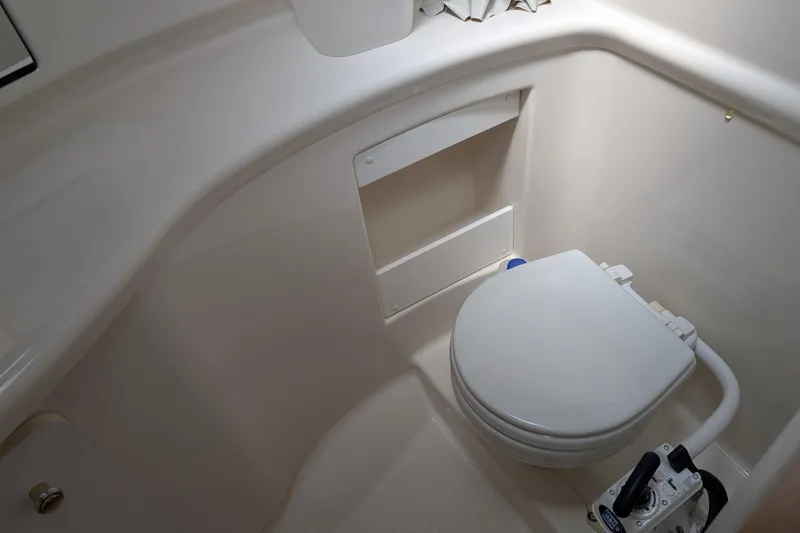 Slide: The Image of 2000 Bayliner 4088 boat bathroom with white marine toilet and compact design. - 35