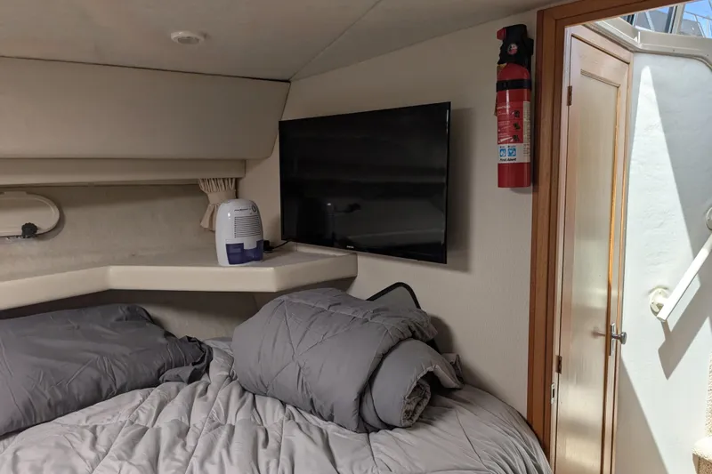 Slide: The Image of Interior of 2000 Bayliner 4088 boat with bed, TV, and fire extinguisher. - 39