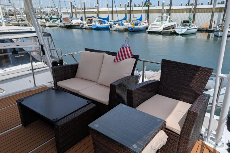 Slide: The Image of Outdoor seating on 2000 Bayliner 4088 yacht, docked at marina with boats in background. - 5